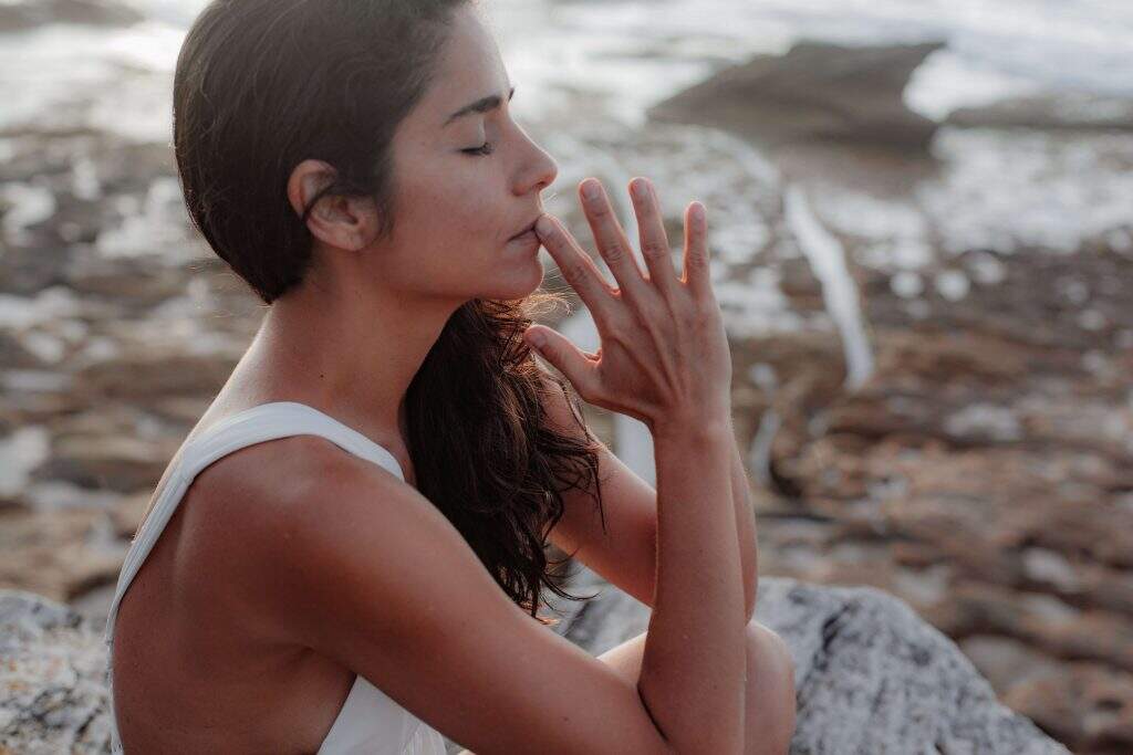 mulher-vestindo-uma-camiseta-branca-meditando